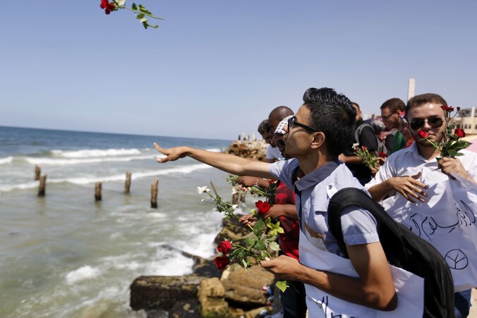 Palestijnen gooien bloemen in zee ter nagedachtenis van de Palestijnse vluchtelingen die vorige week voor de kust van Malta omkwamen.
