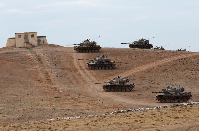 Turkse tanks wachten aan de Syrische grens op toestemming om over te steken.