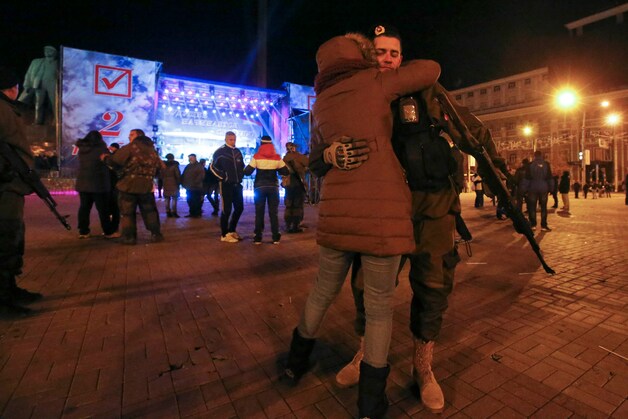 Een pro-Russische separatist omhelst een vrouw aan het einde van de verkiezingsdag in Donetsk.