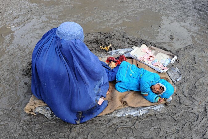 Eem Afghaanse vrouw en haar kind bedelen in Kabul om giften.