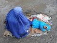 Eem Afghaanse vrouw en haar kind bedelen in Kabul om giften.