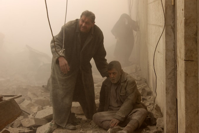 Een Syrische man helpt een gewonde man onder het puin vandaag in Aleppo, waar vandaag opnieuw luchtaanvallen zijn gepleegd.