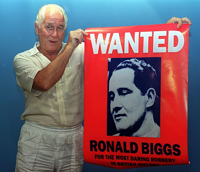 Foto uit 1994. Ronny Biggs toont een poster met zijn beeltenis op.