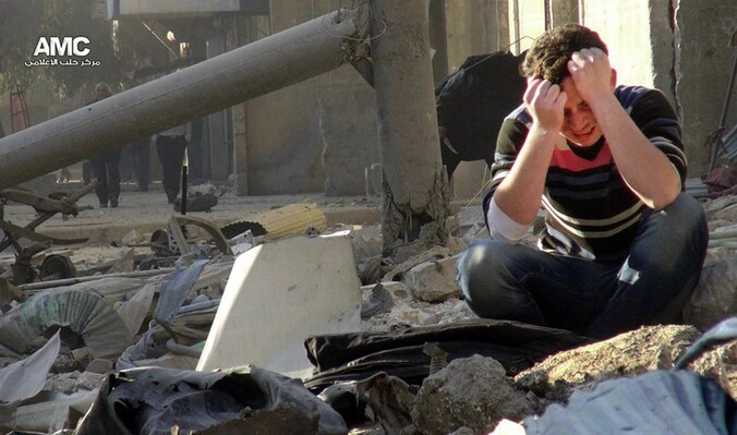 Een jongen in Aleppo huilt op de resten van een gebouw dat is geraakt door een zogeheten "vatenbom".