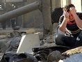 Een jongen in Aleppo huilt op de resten van een gebouw dat is geraakt door een zogeheten "vatenbom".