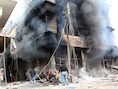 Mannen proberen een brand in een gebouw in Damascus te blussen.