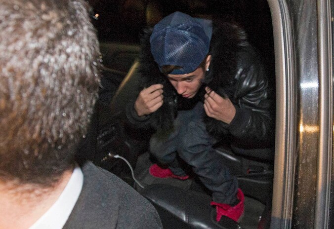 Omgeven door security-agenten arriveert Justin Bieber aan een politiekantoor in de Canadese grootstad Toronto.