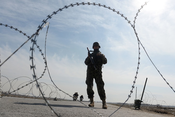 Een Afghaanse soldaat houdt de wacht bij de ingang van de gevangenis in Bagram.