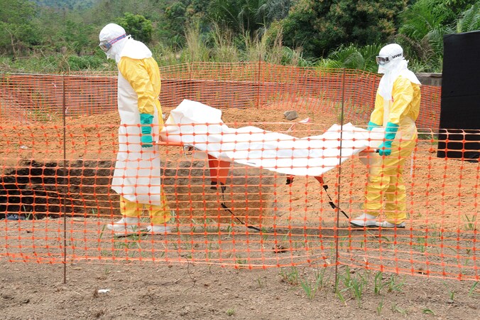 Medewerkers van Artsen zonder Grenzen begraven een slachtoffer van het ebolavirus in Guekedou, Guinee.