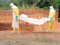 Medewerkers van Artsen zonder Grenzen begraven een slachtoffer van het ebolavirus in Guekedou, Guinee.