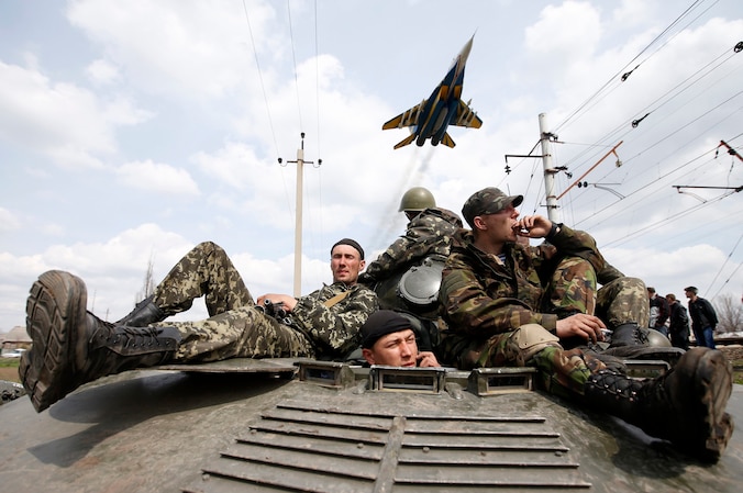Een gevechtsvliegtuig vliegt boven Oekraïense soldaten.