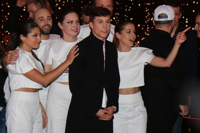 Loïc Nottet en de achtergrondzangeressen vieren in de Green Room.
