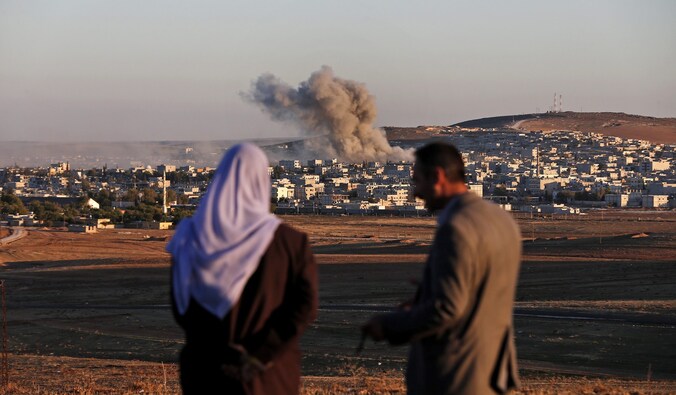 Een Turks koppel ziet hoe een explosie Kobani treft. (Archiefbeeld)
