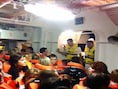 Crewelden in reddingsvesten begeleiden passagiers op een reddingsboot. Andere bemanningsleden kweten zich minder plichtsbewust van hun taak.