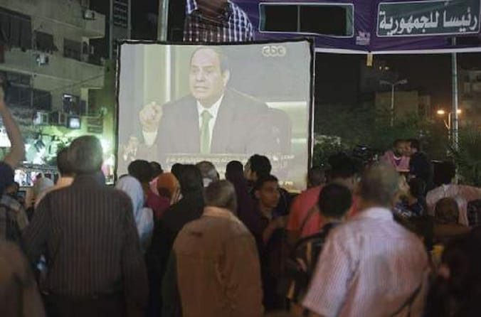 Op straat in Caïro wordt het interview met Sisi op een groot scherm uitgezonden