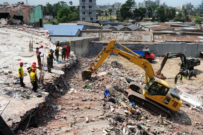 Reddingswerkers zijn bezig bij het ingestorte gebouw in Bangladesh