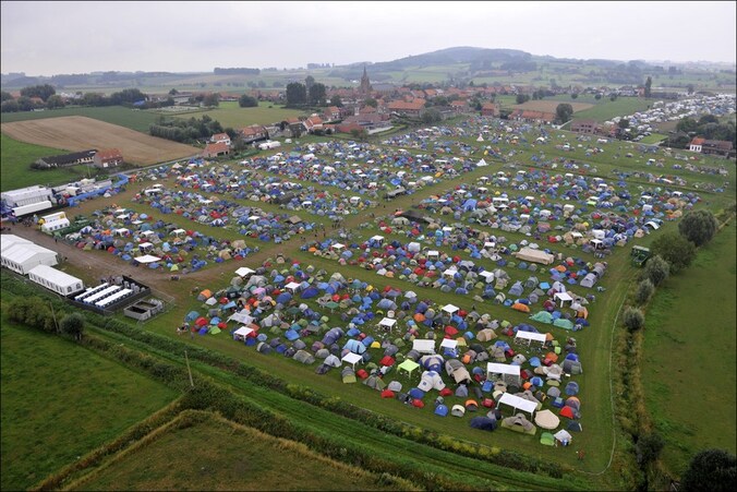 De campingweide van het festival en bovenaan in beeld de kerk van Dranouter, waar het Rode Kruis toegang tot heeft.