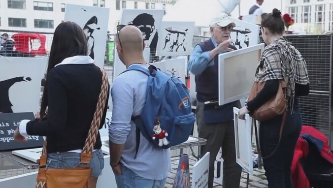 De vrouw rechts koopt een werk van een door Banksy ingehuurde marktkoopman. Zij kan een financiële klapper maken.