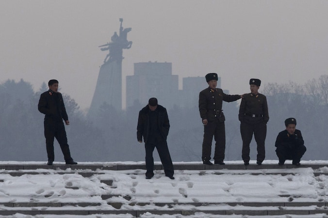Noord-Koreaanse soldaten aan de oever van de Han rivier, met op de achtergrond het standbeeld van Chollima, een gevleugeld paard in Pyongyang.