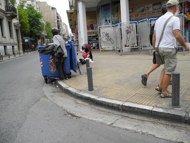 Mensen die in afvalcontainers zoeken naar al wat eet- of bruikbaar is, niemand kijkt er nog van op in Athene.