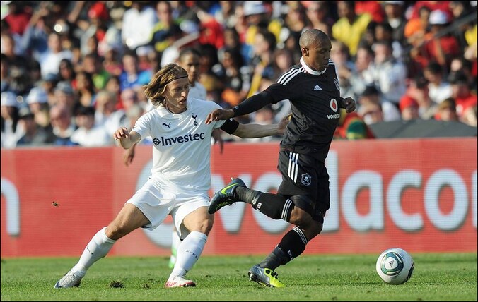 Andile Jali gaat voor Luca Modric met de bal aan de haal in een vriendschappelijke wedstrijd in 2011.