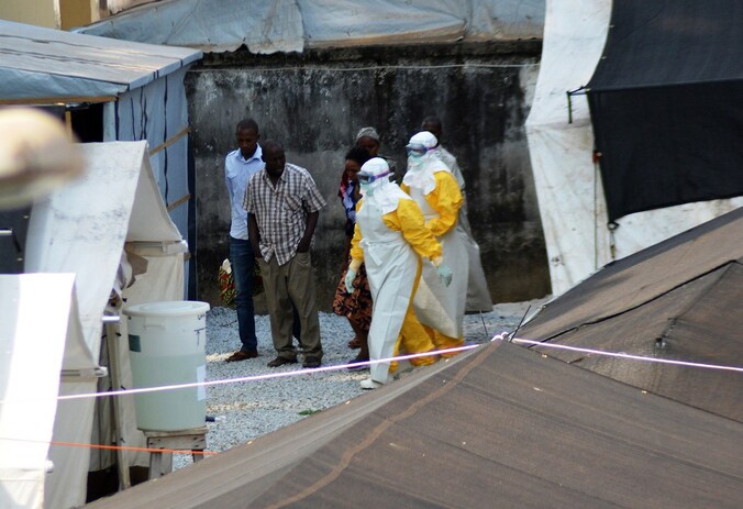 Medewerkers van een gezondheidsdienst in Sierra Leone dragen beschermende kleding op de plek waar het Donka-ziekenhuis patiënten met ebola heeft opgevangen.