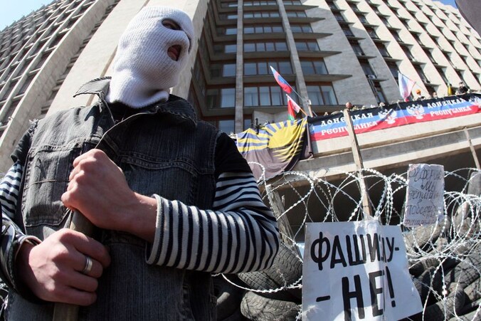 Een gemaskerde pro-Russische activist bewaakt een barricade in de stad Donetsk in het oosten van Oekraïne.