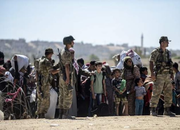 Syrische Koerden wachten bij de grensovergang bij Suruc, in de provincie Sanliurfa.