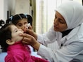 Een werknemer van UNICEF dient een Syrisch kind in de hoofdstad Damascus een vaccinatie toe tegen polio.
