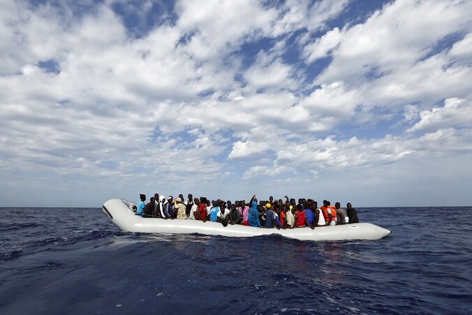 Een bootje met migranten dobbert op de Middellandse Zee voor de kust van Lampedusa.