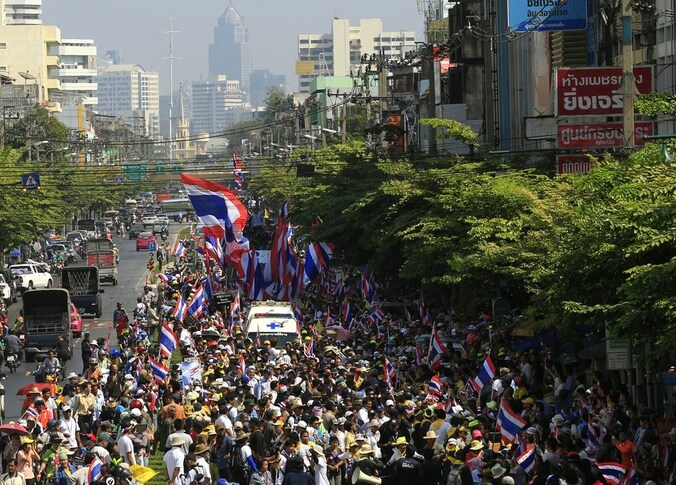 Tegenstanders van de regering van premier Yingluck Shinawatra marcheren door de straten van Bangkok.
