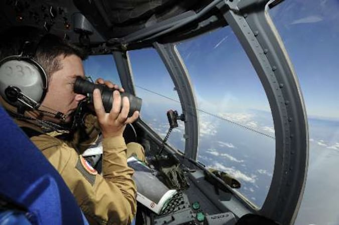 Militairen speuren naar brokstukken van het neergestorte toestel.