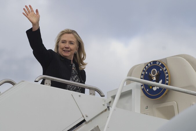 Hillary Clinton op de trappen van het vliegtuig.
