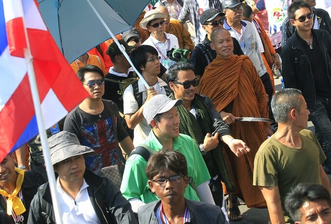 Een Boeddhistische monnik loopt mee in een demonstratie tegen de Thaise regering.