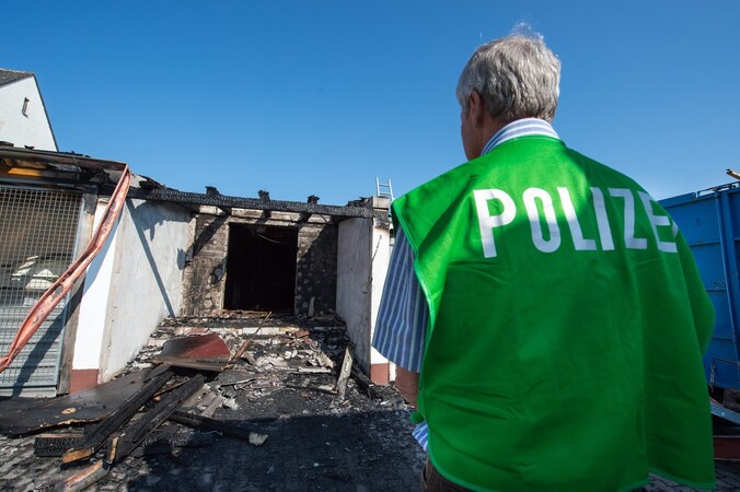 Een onderzoeker van de politie bekijkt de schade aan een onderkomen voor asielzoekers in Reichertshofen.