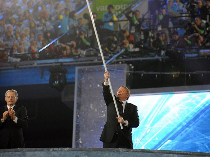 Anatoli Pasjomov zwaait met de Olympische vlag in Toronto in 2010.