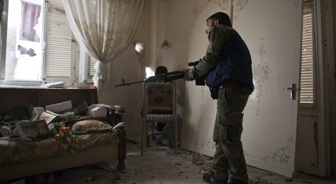 Een Syrische rebel in een woning in Allepo.