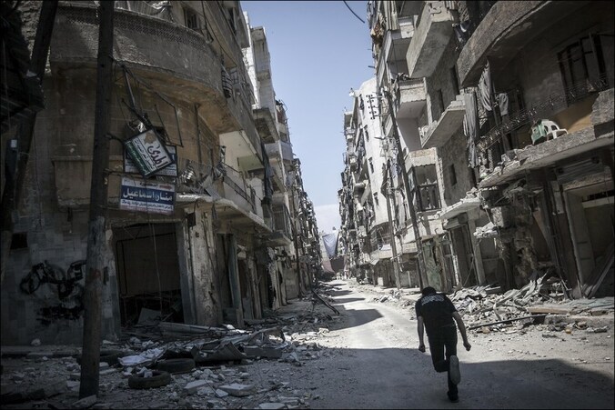Een aanhanger van de Syrische oppositie probeert in het zwaar gehavende Aleppo buiten schot te blijven.
