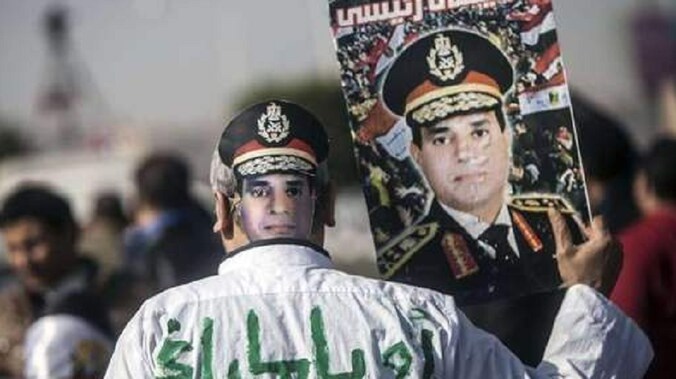 Een aanhanger van legerleider al-Sisi met een portret van hem op masker en pamflet.