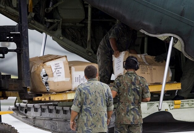 Braziliaanse militairen laden lijkzakken uit. Er is nog geen enkel slachtoffer gevonden.