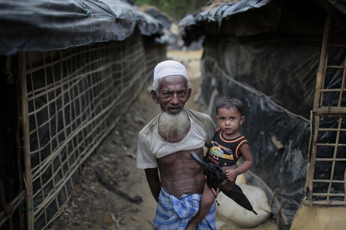 Een oudere Rohingya man met zijn kleinzoon op de arm in het vluchtelingenkamp van Cox's Bazar in Bangladesh.