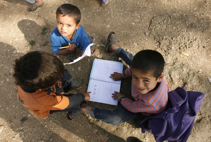 Jonge Syrische vluchtelingen doen hun huiswerk in een VN-vluchtelingenkamp in Libanon.
