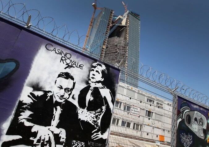 Een van de graffiti-werken toont Mario Draghi en Angela Merkel in een Casino Royale-setting.