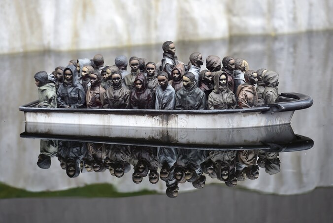 Bezoekers aan 'Dismaland' (Naargeestigland) kunnen miniatuurbootjes met vluchtelingen besturen.