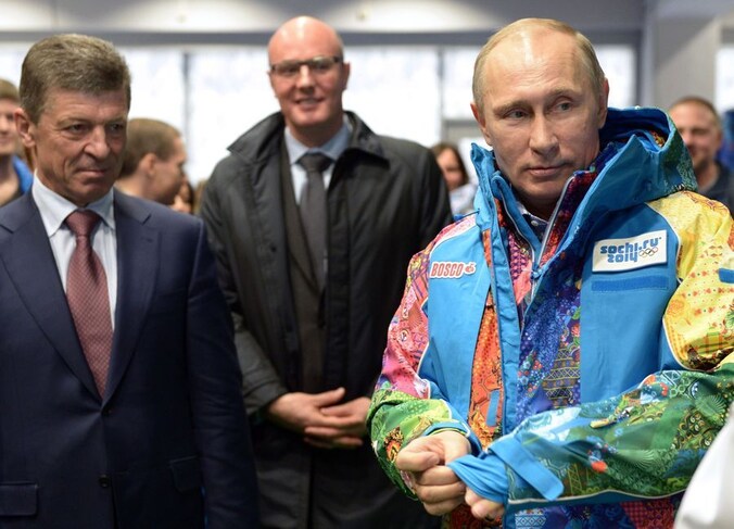 President Poetin past een vrijwilligersjas van de Olympische Spelen in Sotchii