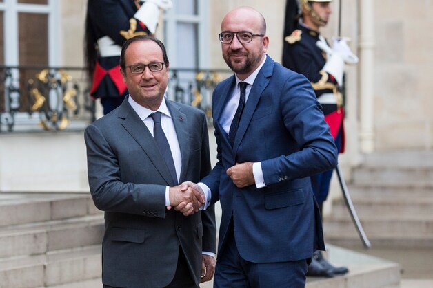 Premier Michel schudt de hand van president Hollande bij zijn aankomst vanmorgen op het Elysée.