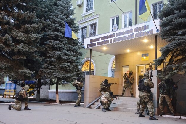Gewapende mannen zaterdag bij het politiebureau in Kramatorsk.