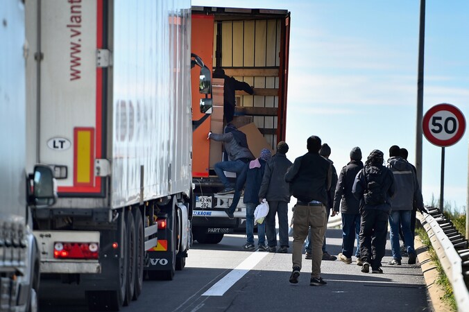 Migranten bij een snelweg in Calais, bij de Eurotunnel, afgelopen juni.
