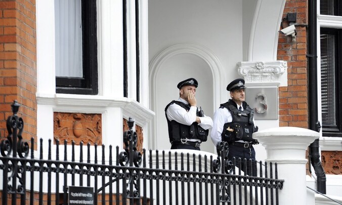 Twee agenten houden de wacht voor de Ecuadoriaanse ambassade in Londen waar Julian Assange zich schuilhoudt.