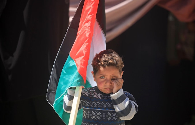 Een Palestijns jongetje tijdens een solidariteitsmars in de Gazastrook voor de Palestijnen in het belegerde Yarmouk kamp, eergisteren.
